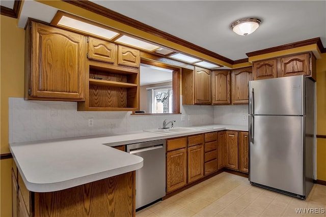 kitchen with brown cabinets, appliances with stainless steel finishes, light countertops, and a peninsula