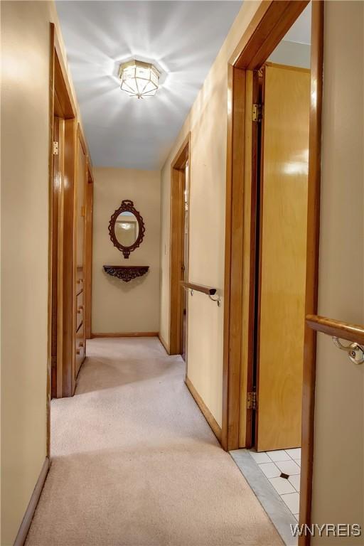 corridor with light carpet and baseboards