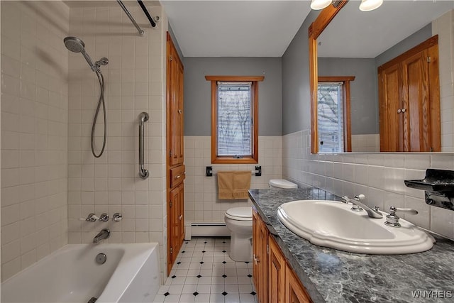 bathroom featuring toilet, a baseboard heating unit, tile walls,  shower combination, and vanity