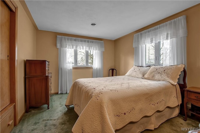 carpeted bedroom with visible vents and baseboards