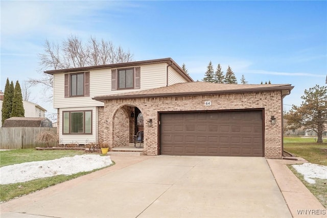 traditional-style house featuring brick siding, fence, concrete driveway, roof with shingles, and an attached garage