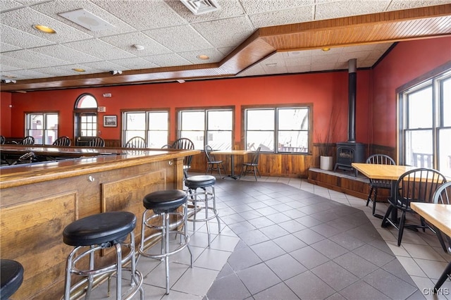 kitchen with visible vents, a healthy amount of sunlight, a wainscoted wall, and a wood stove