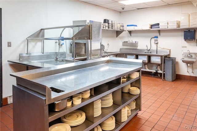 kitchen featuring a drop ceiling, stainless steel countertops, and open shelves