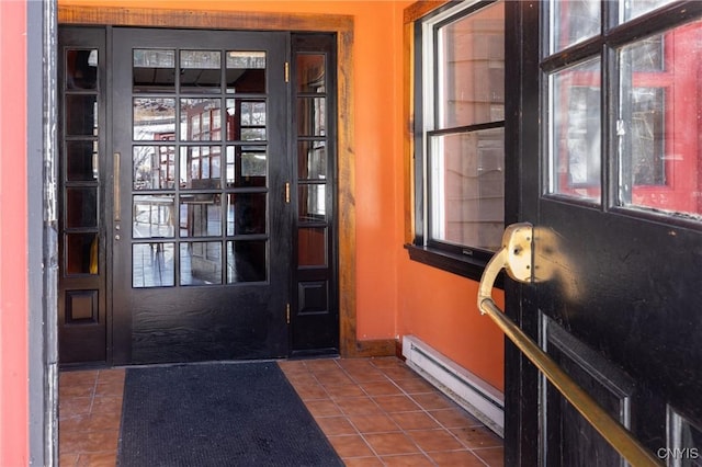 doorway to outside featuring tile patterned flooring, plenty of natural light, baseboards, and a baseboard radiator