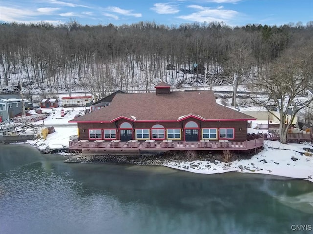 snow covered property featuring a water view