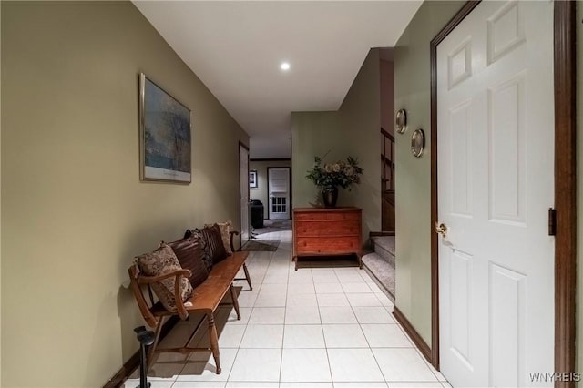 corridor with light tile patterned flooring, stairway, recessed lighting, and baseboards