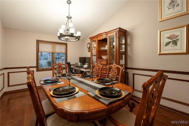 dining room featuring a wainscoted wall, an inviting chandelier, wood finished floors, and vaulted ceiling