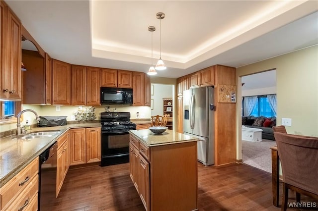 kitchen with a sink, a raised ceiling, black appliances, and dark wood-style flooring