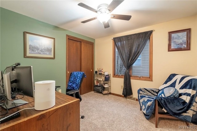 office space featuring a ceiling fan, light colored carpet, and baseboards