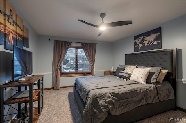 bedroom featuring light colored carpet, a ceiling fan, and baseboards