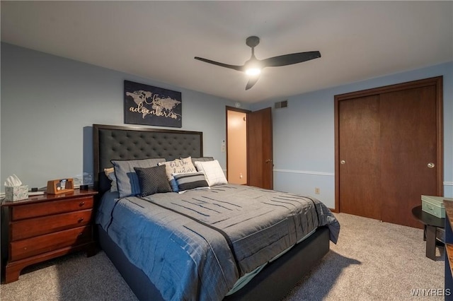 carpeted bedroom featuring visible vents, a closet, and ceiling fan