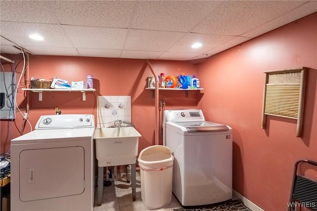 laundry room featuring baseboards, laundry area, a sink, tile patterned flooring, and washer and dryer