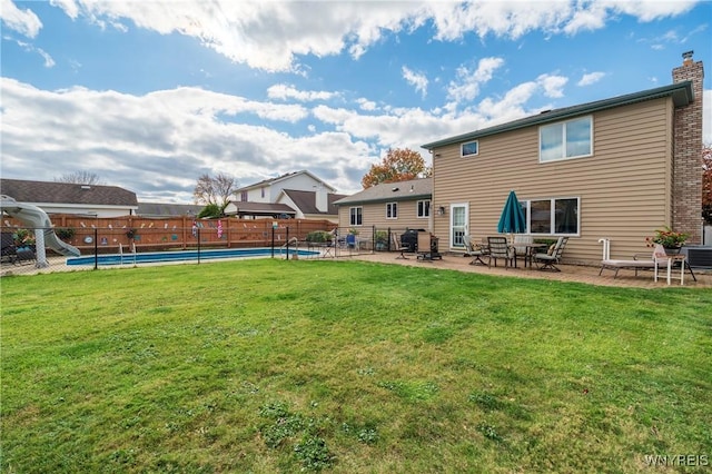 view of yard featuring a patio area, a fenced in pool, and fence