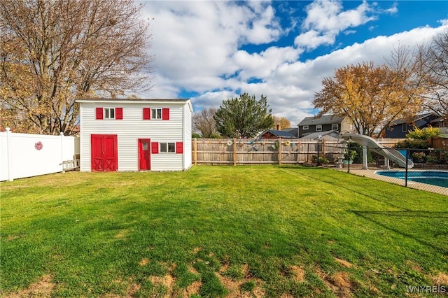 view of yard featuring a fenced in pool, an outdoor structure, and a fenced backyard