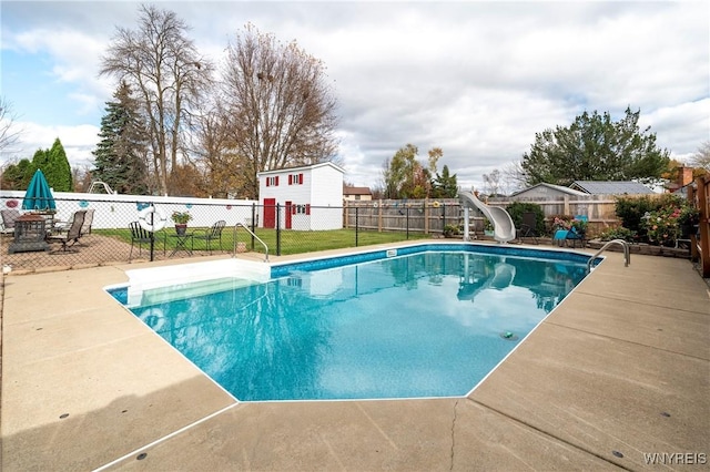 view of pool featuring a fenced in pool, a water slide, a fenced backyard, and a patio area