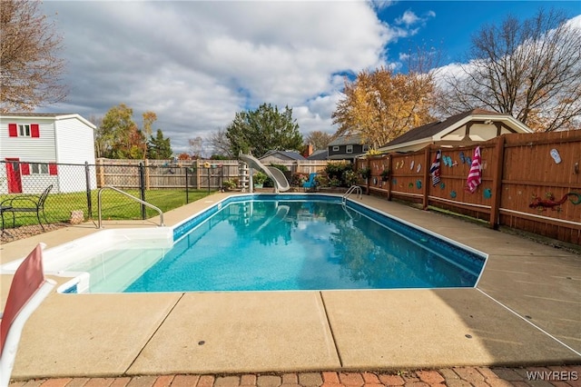 view of swimming pool with a fenced backyard, a fenced in pool, and a water slide