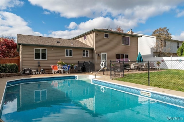 view of pool featuring a patio area, a yard, a fenced in pool, and fence