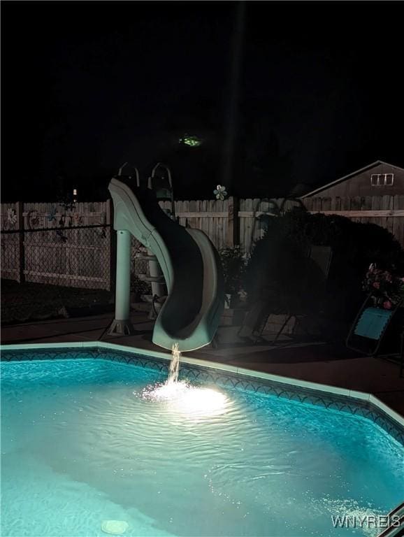 view of pool featuring a fenced in pool, a water slide, and fence