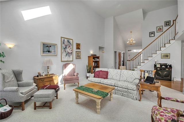 carpeted living room with a skylight, stairs, an inviting chandelier, and a towering ceiling