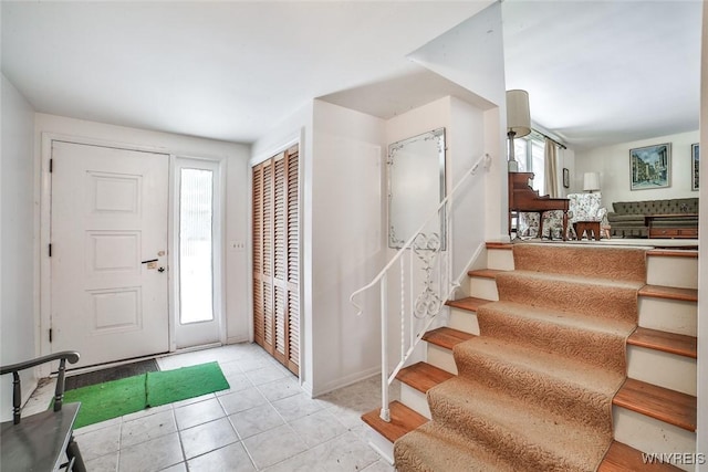 entrance foyer featuring stairs, light tile patterned floors, and a wealth of natural light