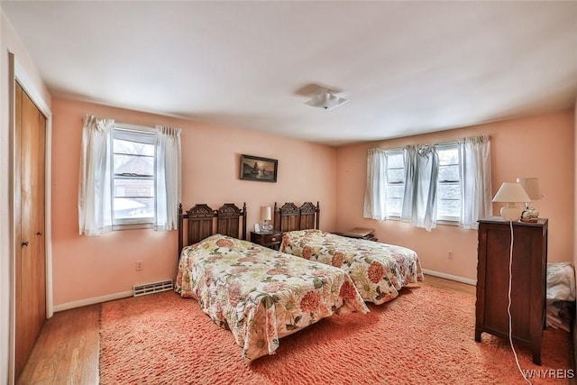 bedroom with a closet, visible vents, multiple windows, and baseboards