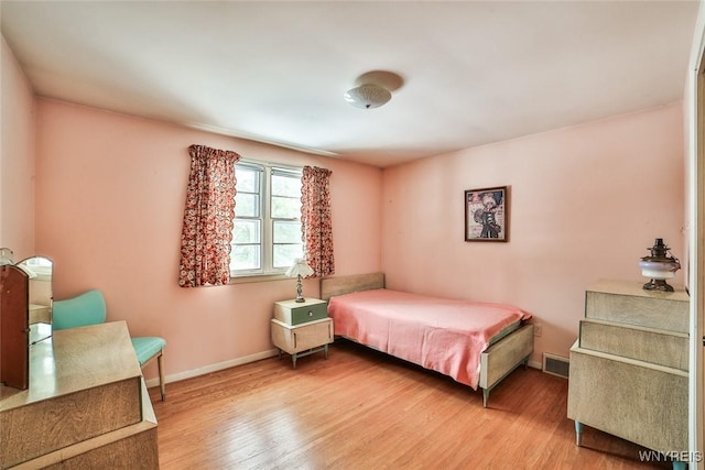 bedroom featuring wood finished floors, visible vents, and baseboards