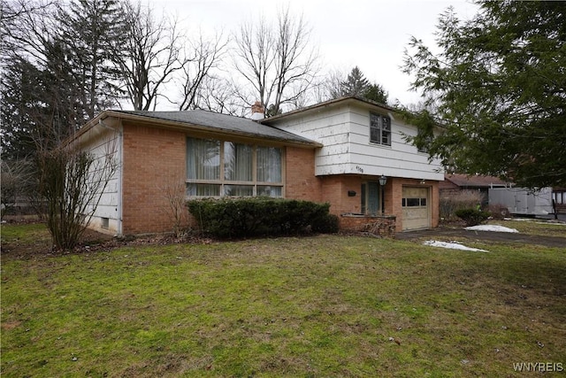 tri-level home featuring a front lawn, aphalt driveway, an attached garage, brick siding, and a chimney