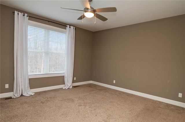 carpeted empty room with baseboards and ceiling fan