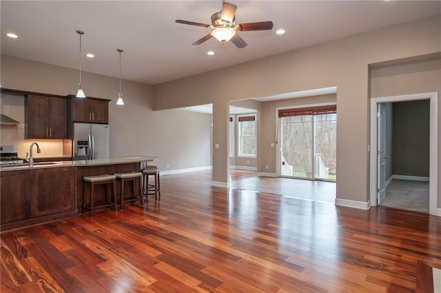 kitchen featuring recessed lighting, appliances with stainless steel finishes, dark wood finished floors, and light countertops