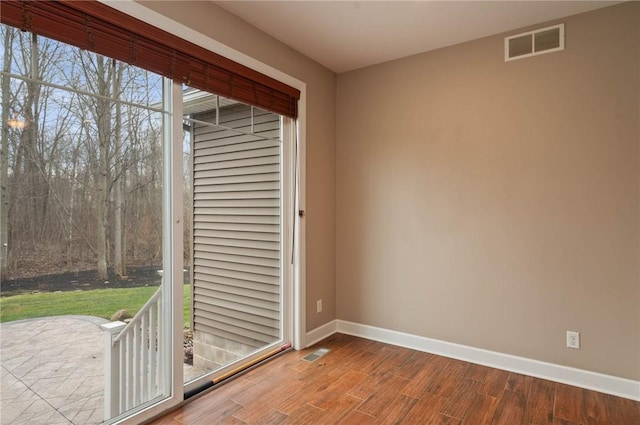 interior space featuring wood finished floors, visible vents, and baseboards