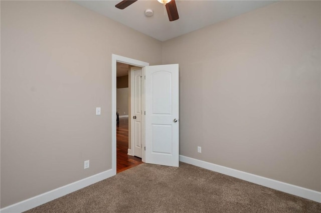 unfurnished room with ceiling fan, baseboards, and carpet