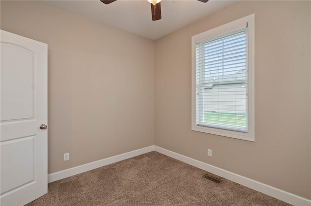 unfurnished room with visible vents, baseboards, carpet, and a ceiling fan