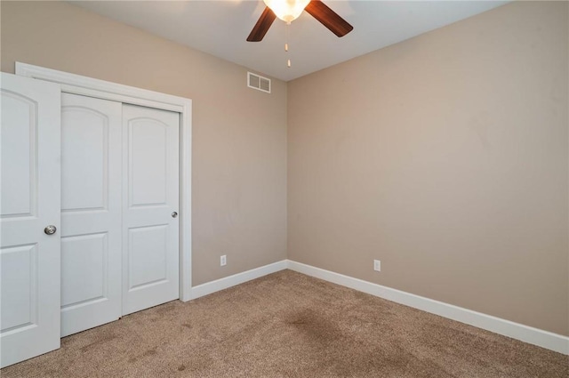 unfurnished bedroom with visible vents, baseboards, light colored carpet, and a closet