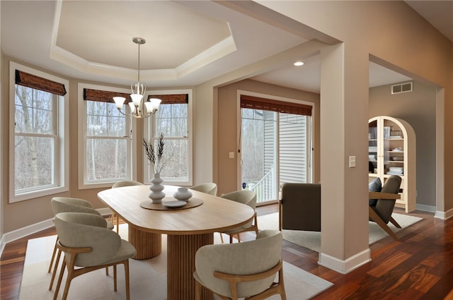 dining room with visible vents, a tray ceiling, an inviting chandelier, baseboards, and dark wood-style flooring