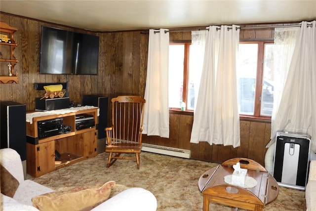 living area with carpet flooring, wood walls, and a baseboard heating unit