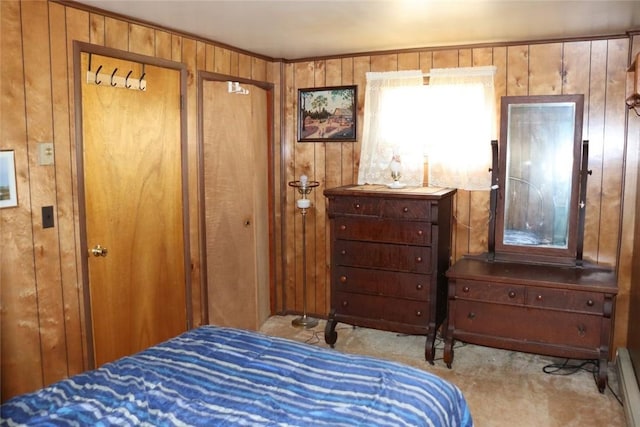 bedroom with baseboard heating, wood walls, carpet, and multiple closets