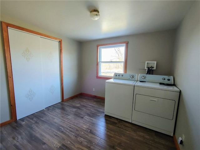 clothes washing area featuring washer and clothes dryer, laundry area, dark wood finished floors, and baseboards