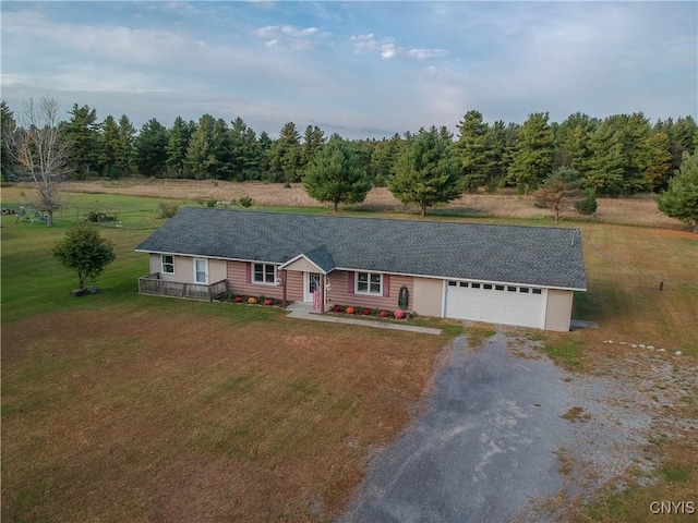 single story home with gravel driveway, a front lawn, and an attached garage