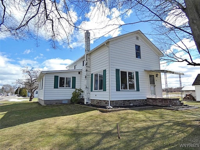 back of house with a yard and a chimney