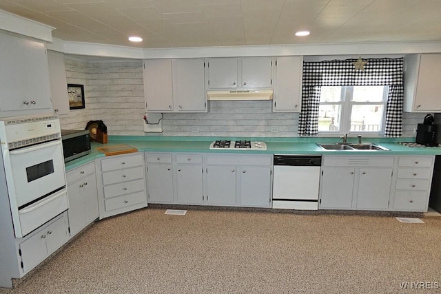 kitchen featuring white appliances, a sink, light countertops, under cabinet range hood, and a warming drawer