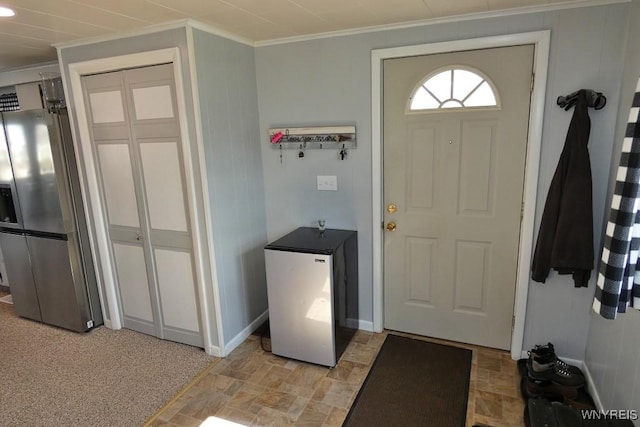 foyer with baseboards, ornamental molding, and stone finish floor