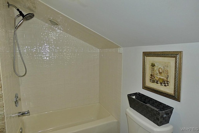 bathroom with vaulted ceiling, toilet, and shower / bathtub combination