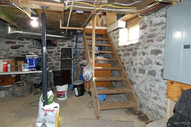 basement featuring stairs and electric panel