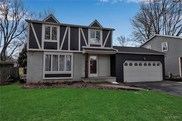 english style home featuring brick siding, driveway, a front lawn, and a garage