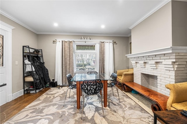 office space featuring ornamental molding, a brick fireplace, baseboards, and wood finished floors