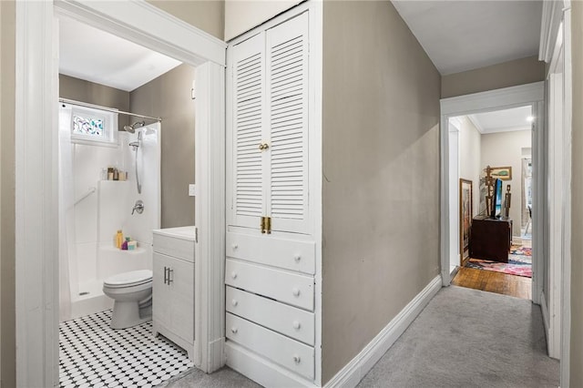 full bath featuring a stall shower, toilet, vanity, and baseboards