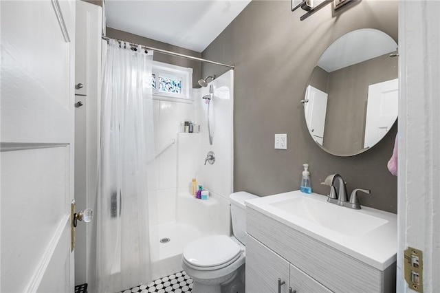 bathroom featuring vanity, toilet, and a stall shower