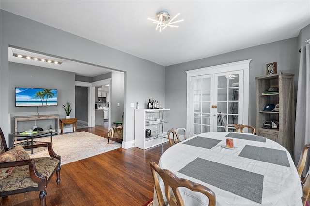 dining space with french doors, baseboards, and wood finished floors