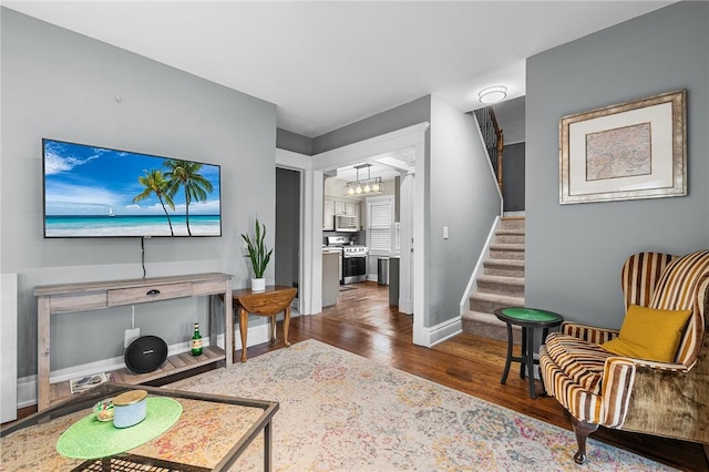 living area featuring stairway, baseboards, and wood finished floors