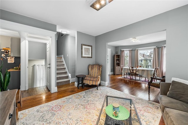 living area featuring baseboards, stairs, and hardwood / wood-style flooring